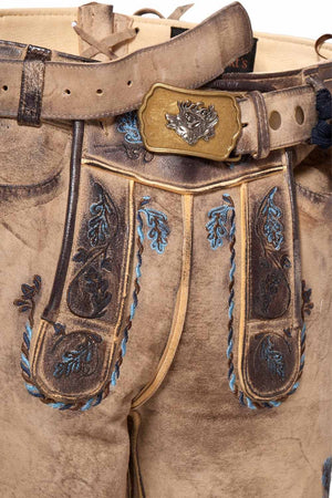 Close-up of german short lederhosen with intricate stitching and vibrant blue floral embroidery. These traditional german leather shorts feature a durable design with an antique brass belt buckle