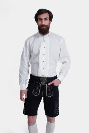 Man wearing Black Edelweiss Lederhosen in Obsidian Twilight with natural embroidery, white shirt, and traditional knee-high socks.