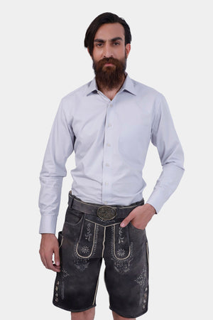 Closed view of a bearded man standing confidently in Black Forest Lederhosen