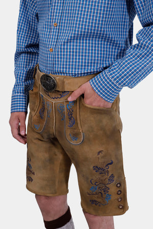 Side view of a man wearing Daniel Brühl Lederhosen, highlighting the side and back pockets, and detailed leg embroidery."
