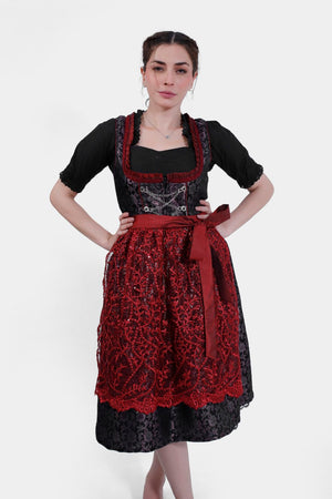 Woman wearing a Dirndl Mariella Rosi in dark cherry glamour, front view, hands on hips.