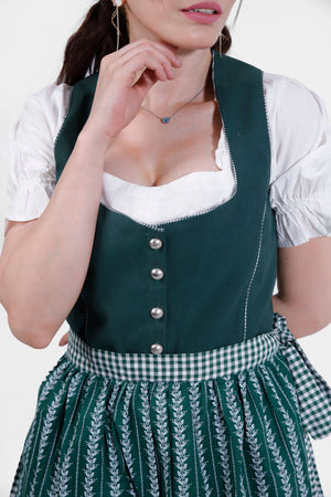 Close-up of the green Dirndl dress with detailed silver buttons and a white blouse underneath.
