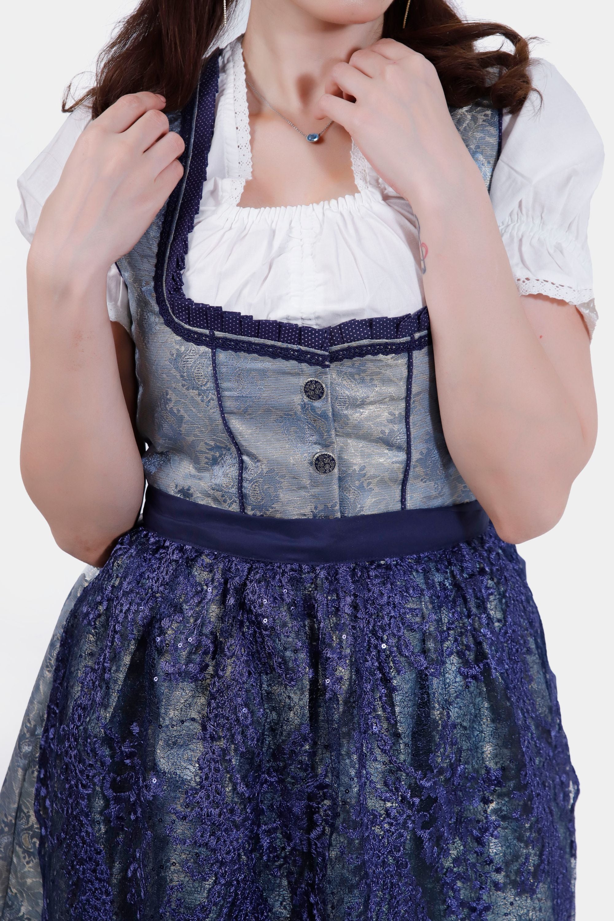 Close-up of the Dirndl's bodice, highlighting the intricate silver and blue fabric with decorative buttons and a detailed neckline.