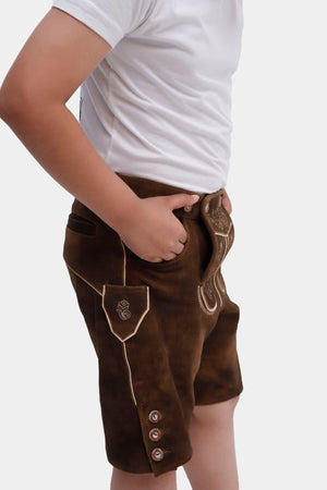 Young boy in traditional Elias Lederhosen, featuring intricate embroidery and brown horn buttons, posing from the side with hands on hips.