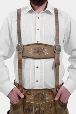 Close-up of a man wearing a white checkered shirt and tan Ernst Happel Bundhosen with suspenders, showing detailed embroidery.