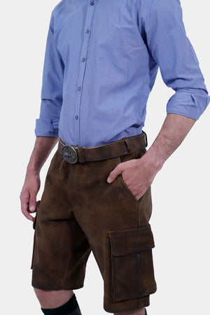 Side view of a man wearing traditional brown leather cargo Lederhosen paired with a blue striped shirt. The image highlights the side pockets and the belt buckle.