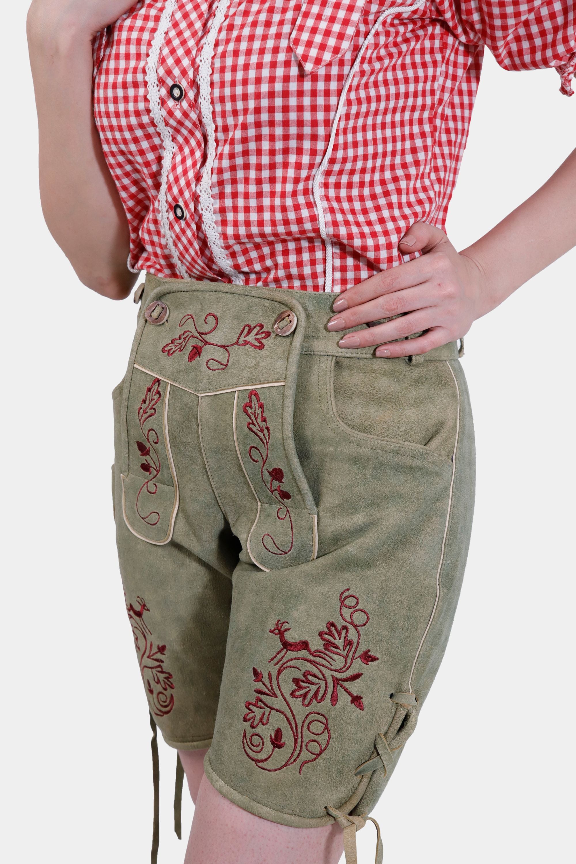 Close-up of the Halle Berry Lederhosen in Olivewood Leaf, showing the intricate natural-colored embroidery on the bib and legs, with a focus on the front pockets.
