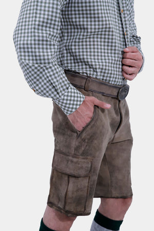 Close-up view focusing on the waist and pocket area of a man wearing grey leather lederhosen and a grey and white checkered shirt. The man has his right hand in the pocket, highlighting the belt and detailed stitching on the lederhosen.