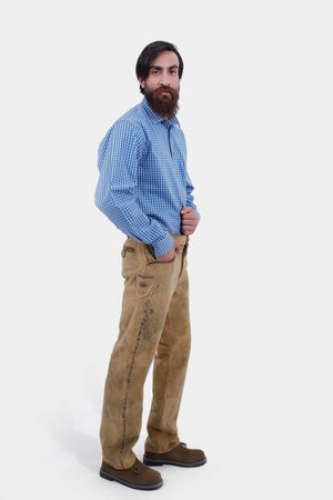 Complete side view of a man wearing Kochelsee Lederhosen Long pants paired with light blue checkered shirt