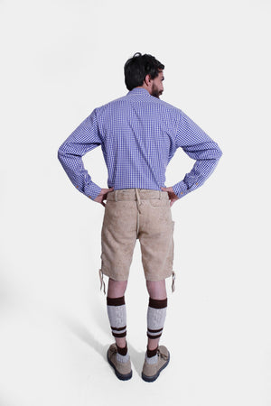 back view of a Man wearing a traditional Bavarian outfit featuring beige suede Lederhosen with blue embroidery, a blue and white checkered shirt, and beige shoes.