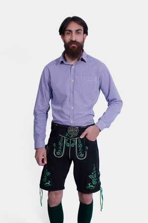 A close-up view of the Mueller Lederhosen, emphasizing the detailed green embroidery and the decorative belt buckle, paired with a blue checkered shirt.