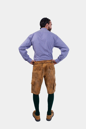 Back view of a man wearing a blue and white checkered dress shirt and brown cargo lederhosen. The back of the lederhosen features pockets, and he has his hands on his hips.