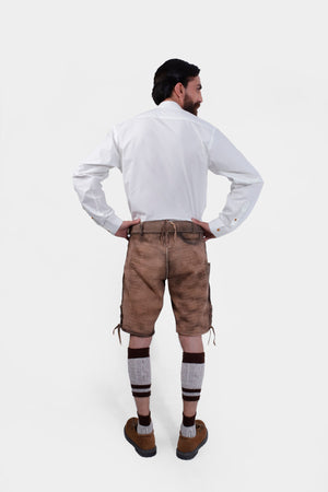 Back view of a man wearing Timber Trail Lederhosen in Caramel Earth with natural embroidery, goat suede leather, and multiple pockets.