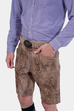 The man wearing the Alpine Eagle Lederhosen with a close-up on the waistband, showing the detailed buckle and leather texture.