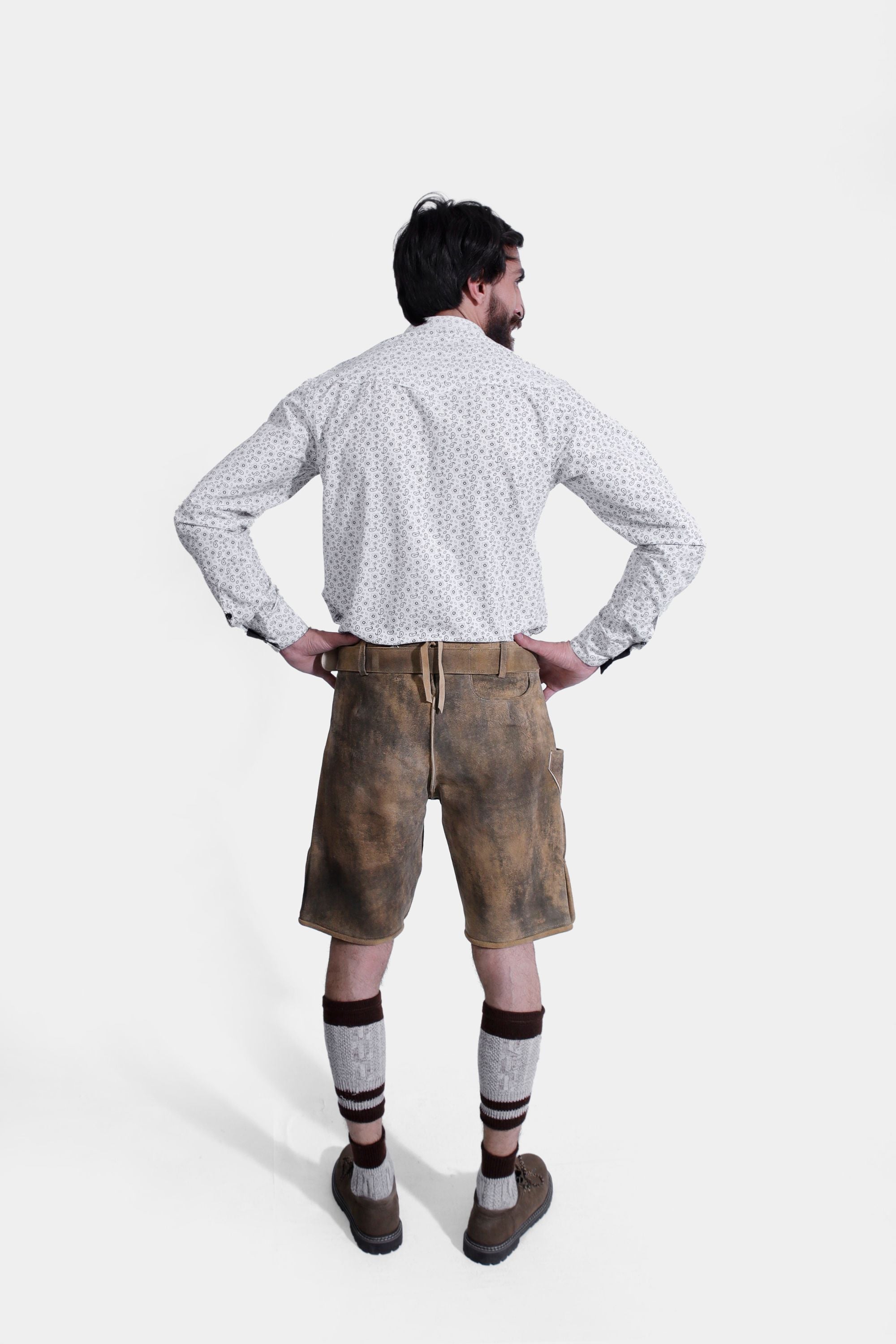 Rear view of full-body shot of the man wearing the traditional german lederhosen.