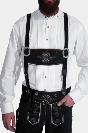 Man wearing Black Edelweiss Lederhosen in Obsidian Twilight with natural embroidery, white shirt, and suspenders