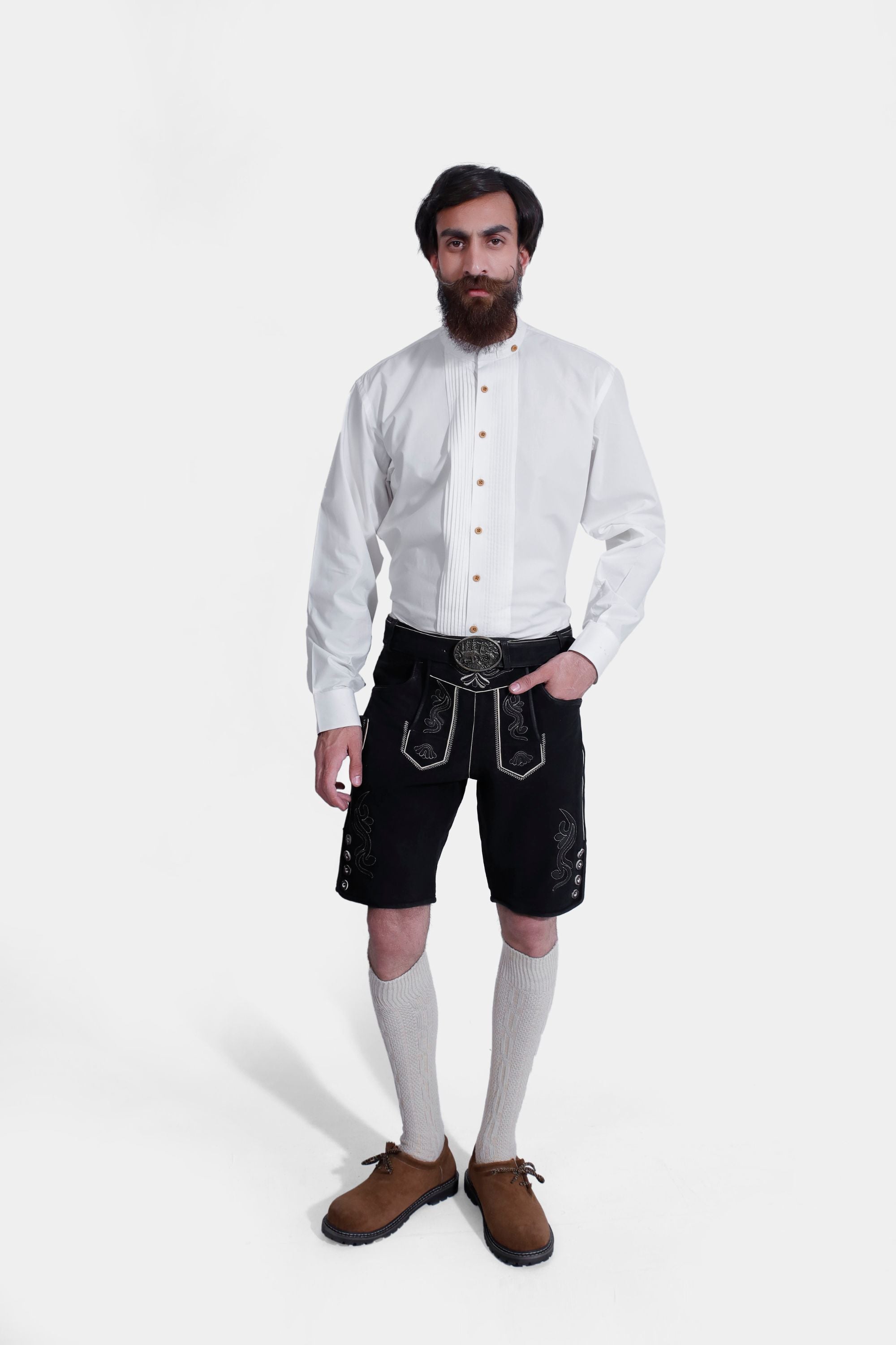 Man wearing Black Edelweiss Lederhosen in Obsidian Twilight with natural embroidery, white shirt, and traditional knee-high socks.