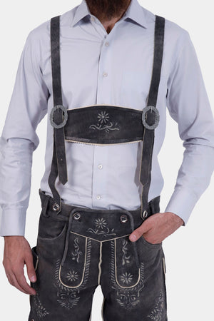 The man in Lederhosen with suspenders, displaying the traditional Bavarian attire from the front.