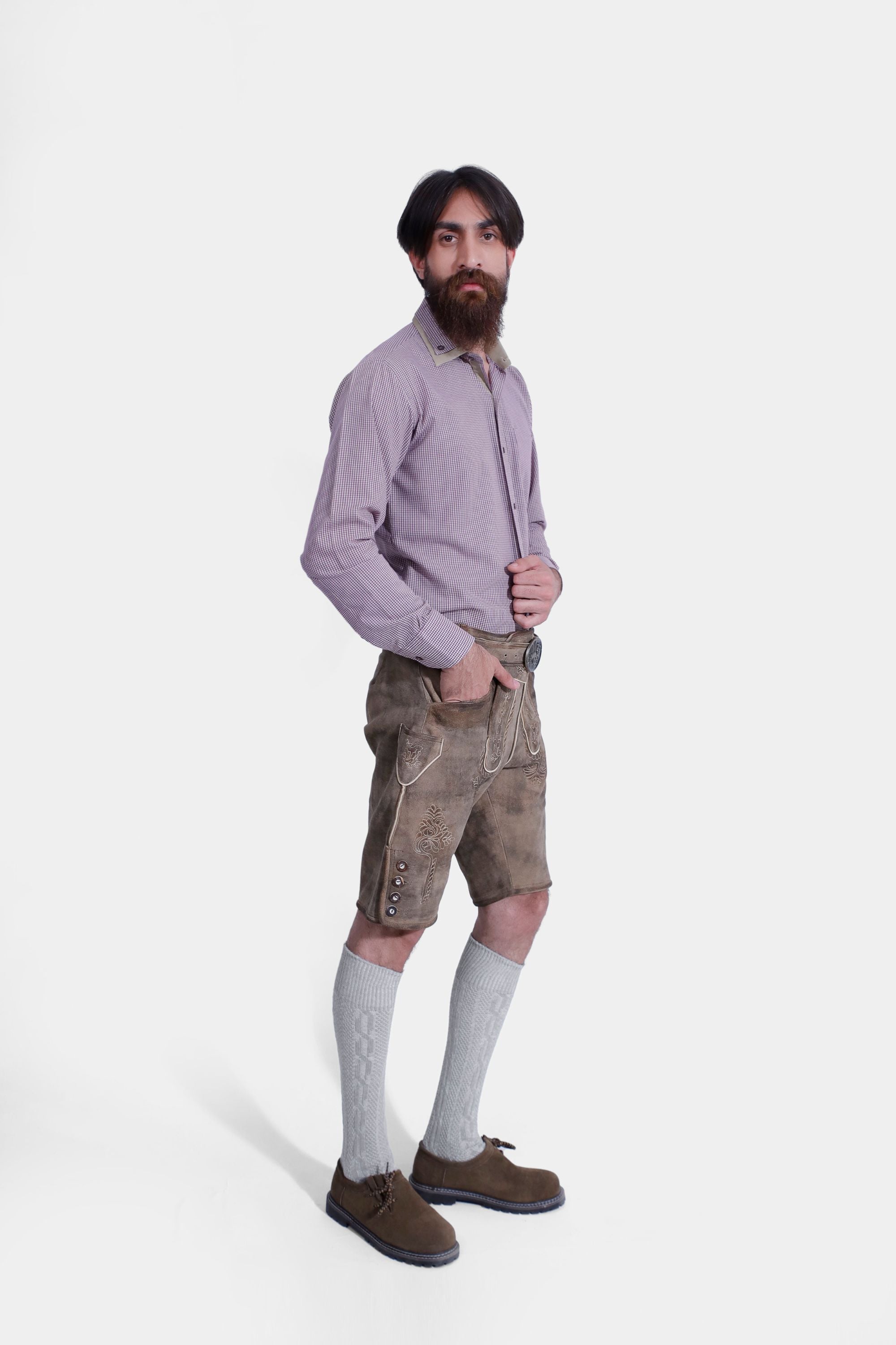 Side view of a Man wearing "Chiemsee Castle Elite Lederhosen" in Opal Mist with intricate embroidery, paired with a checkered shirt.