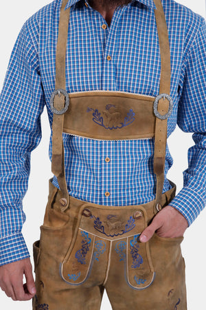 Man wearing Daniel Brühl Lederhosen with suspenders, showcasing detailed embroidery on the bib and legs.