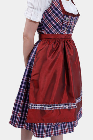 The other side view of the dirndl dress highlighting the tied red apron and the pleated plaid skirt
