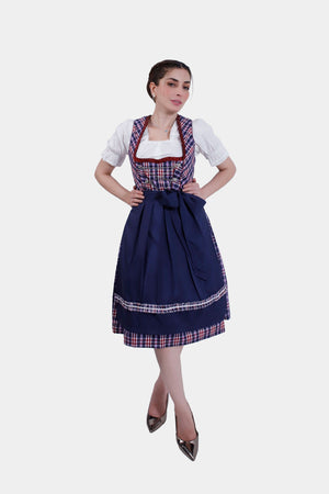Full-body view of the woman in the Dirndl dress, standing confidently with one hand on her hip. The navy blue apron and plaid skirt create a classic and elegant look.
