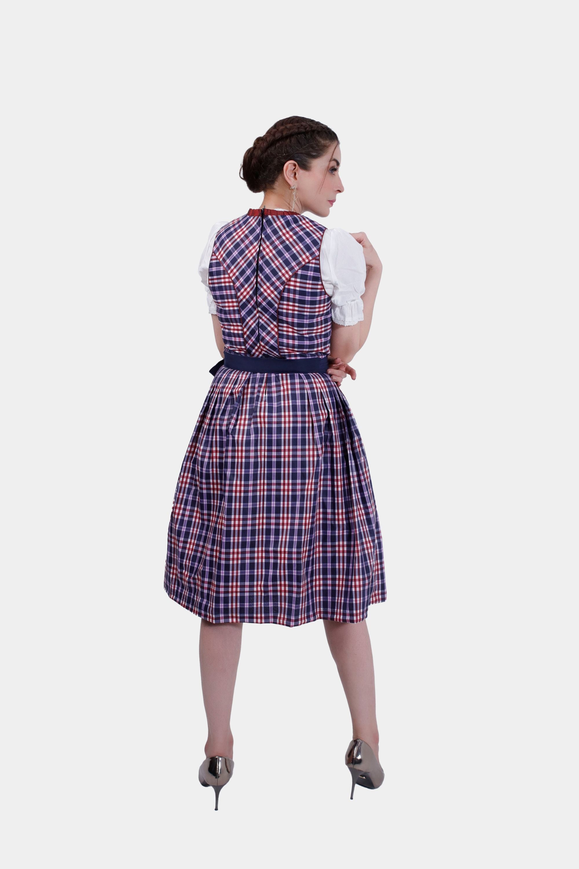 Back view of the Dirndl dress, showing the plaid pattern extending across the bodice and skirt, with the apron tied neatly in a bow at the back.