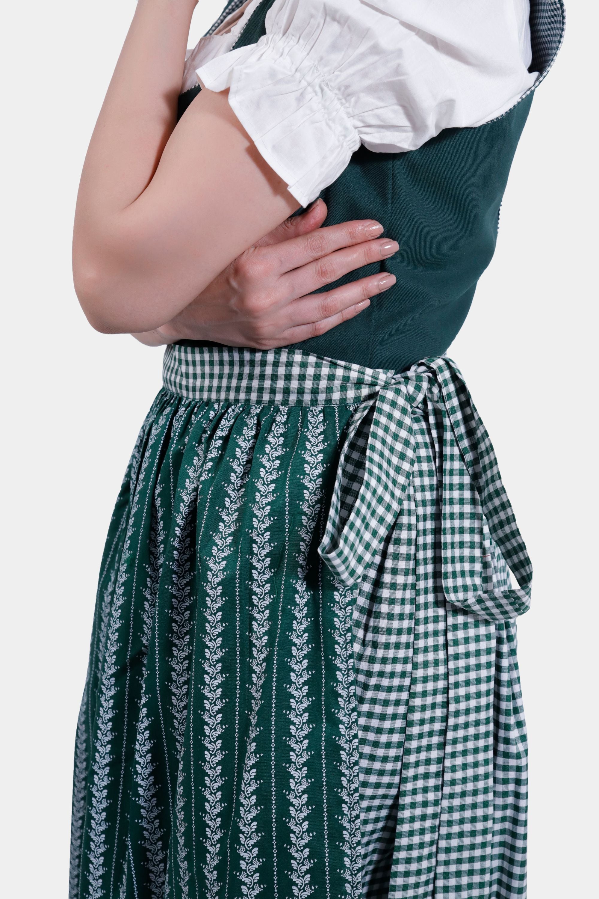 Side view of the green Dirndl dress, showing the checkered apron tied in a bow.