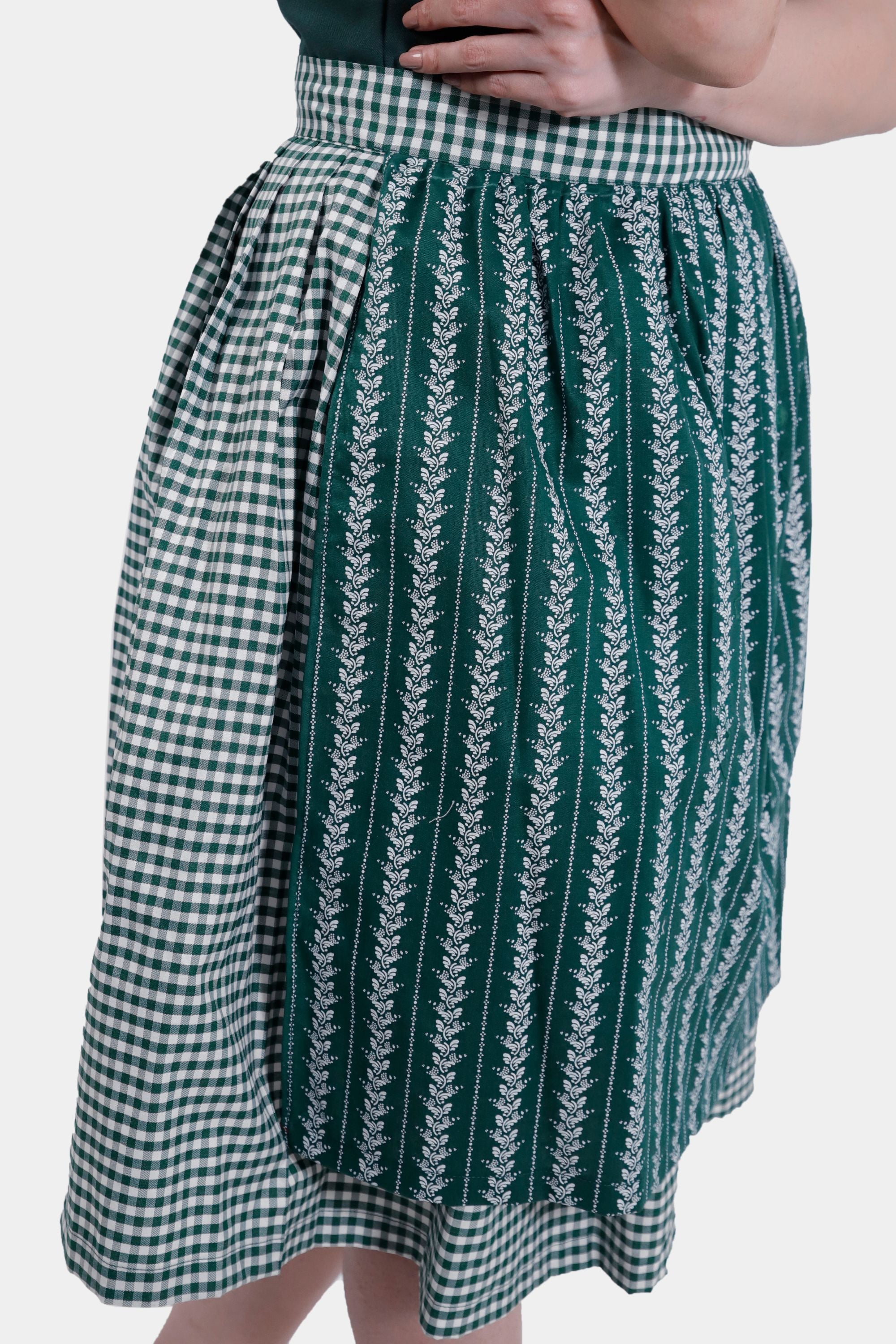 Close-up of the checkered apron with white floral patterns on the green skirt.