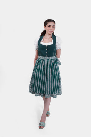 Full view of the green Dirndl dress, worn with green sandals, showing the model standing gracefully.