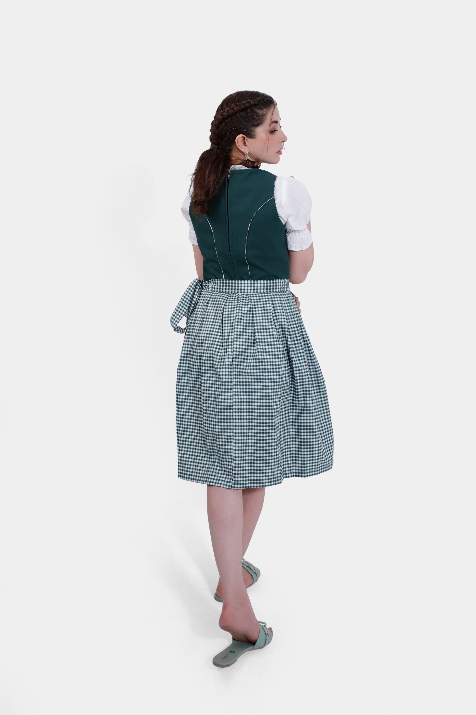 Back view of the green Dirndl dress with a checkered apron tied at the waist.