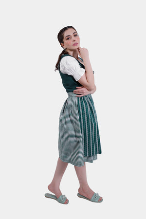 Side profile of the model wearing the green Dirndl dress, with her hand resting on her arm.