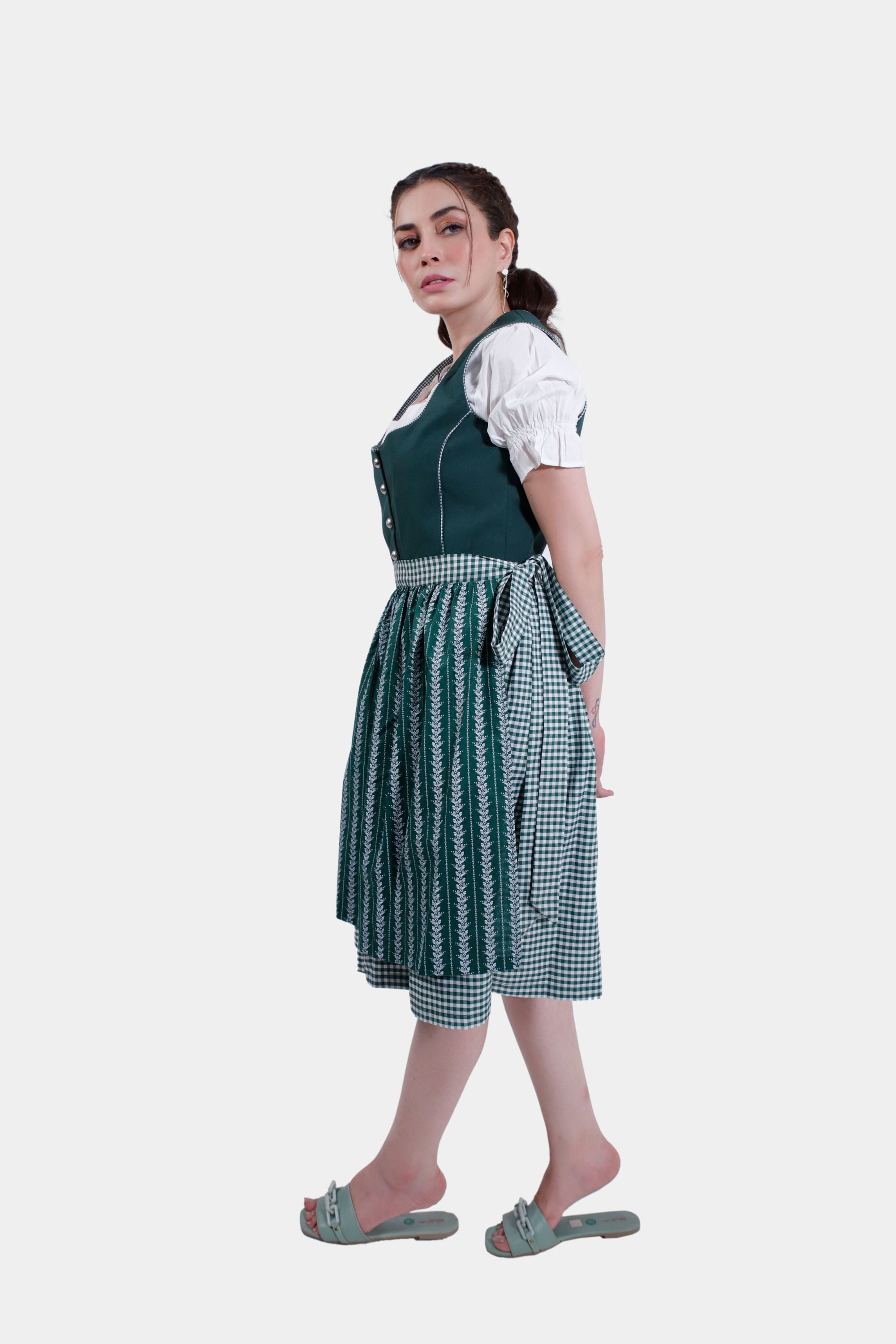 Side view of the model in the green Dirndl dress, showcasing the flow of the skirt and checkered patterns.