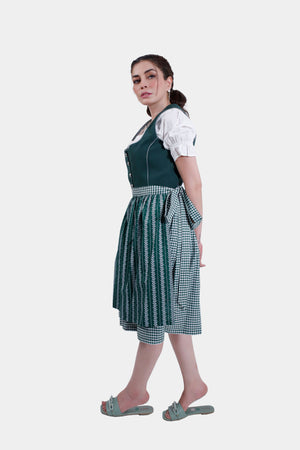 Side view of the model in the green Dirndl dress, showcasing the flow of the skirt and checkered patterns.