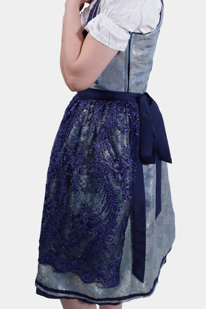 Side view of the Dirndl dress, showcasing the lace apron tied with a navy blue ribbon.