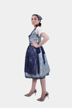 Side profile of the woman in the Dirndl dress, hands on hips, emphasizing the tailored fit and flowing skirt.