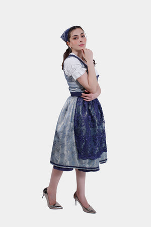 Three-quarter view of the woman in the Dirndl dress, with one hand under her chin, highlighting the lace details on the apron.