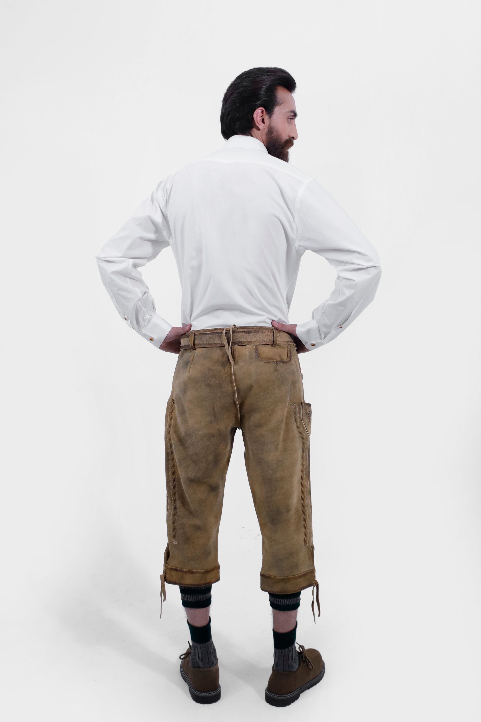 back view of a man in a plain white shirt and tan Ernst Happel Bundhosen, highlighting the back pockets and stitching details.