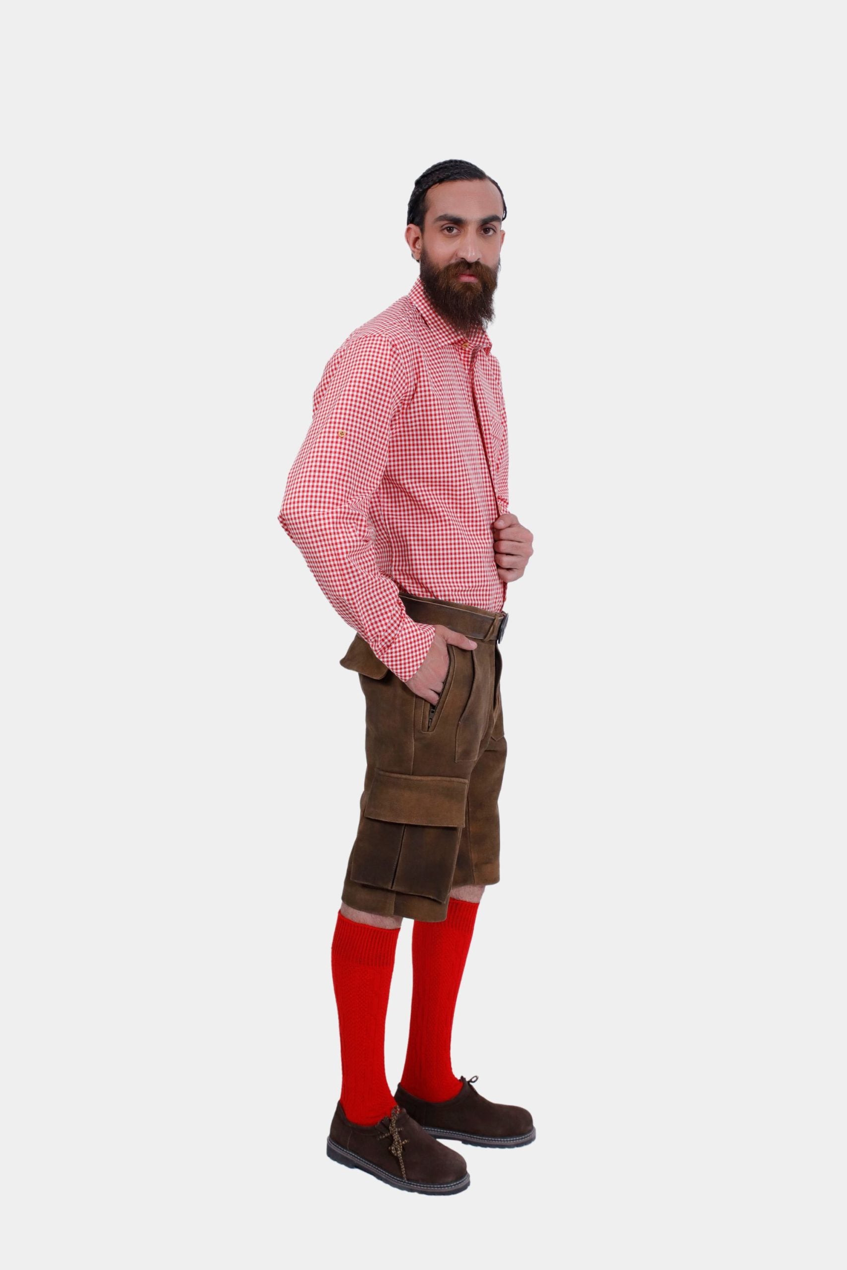 A side view of the man wearing brown leather lederhosen and a red checkered shirt, highlighting the belt and the pockets.