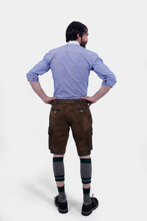 Rear view of a man wearing traditional brown leather cargo Lederhosen and a blue striped shirt. The image showcases the back details of the Lederhosen, including the side pockets and the belt. The man is also wearing traditional Bavarian socks and black shoes.