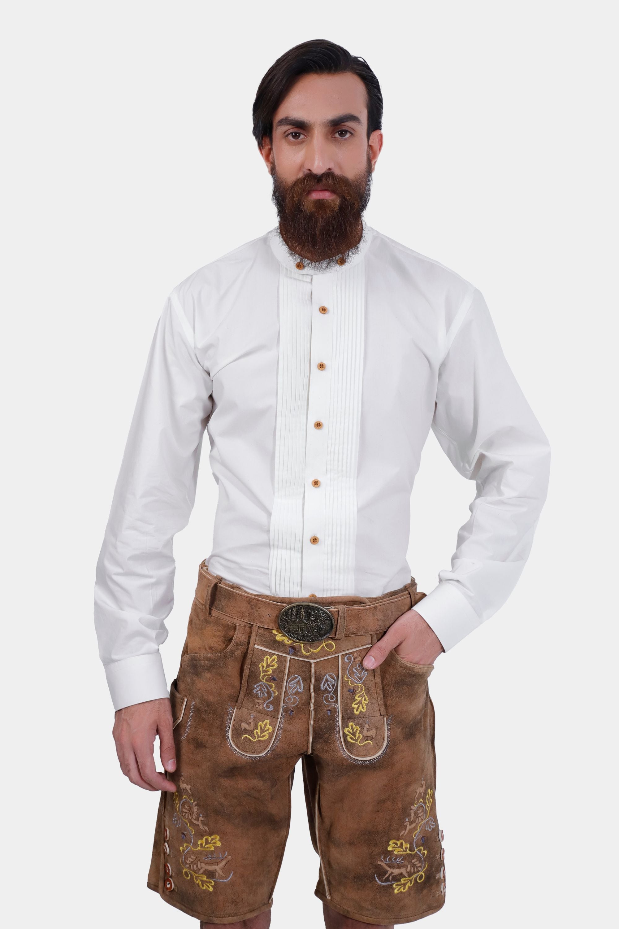 A bearded man wearing traditional Gerd Muller Lederhosen with a white, high-collared button-down shirt, showcasing intricate embroidery.