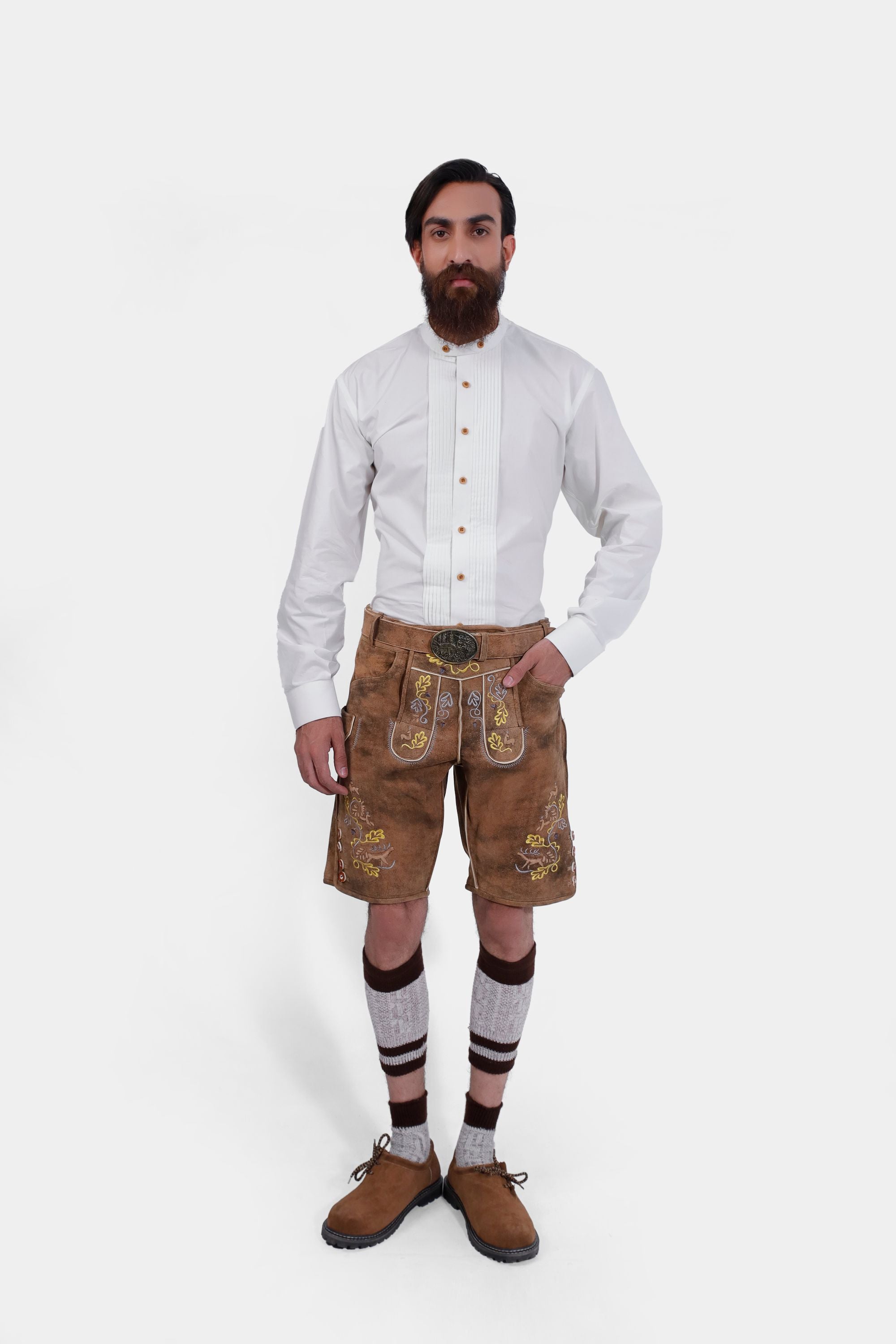 Complete front view of a bearded man standing confidently in Gerd Muller Lederhosen, complete with knee-high socks and traditional shoes.
