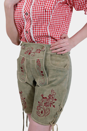 Close-up of the Halle Berry Lederhosen in Olivewood Leaf, showing the intricate natural-colored embroidery on the bib and legs, with a focus on the front pockets.