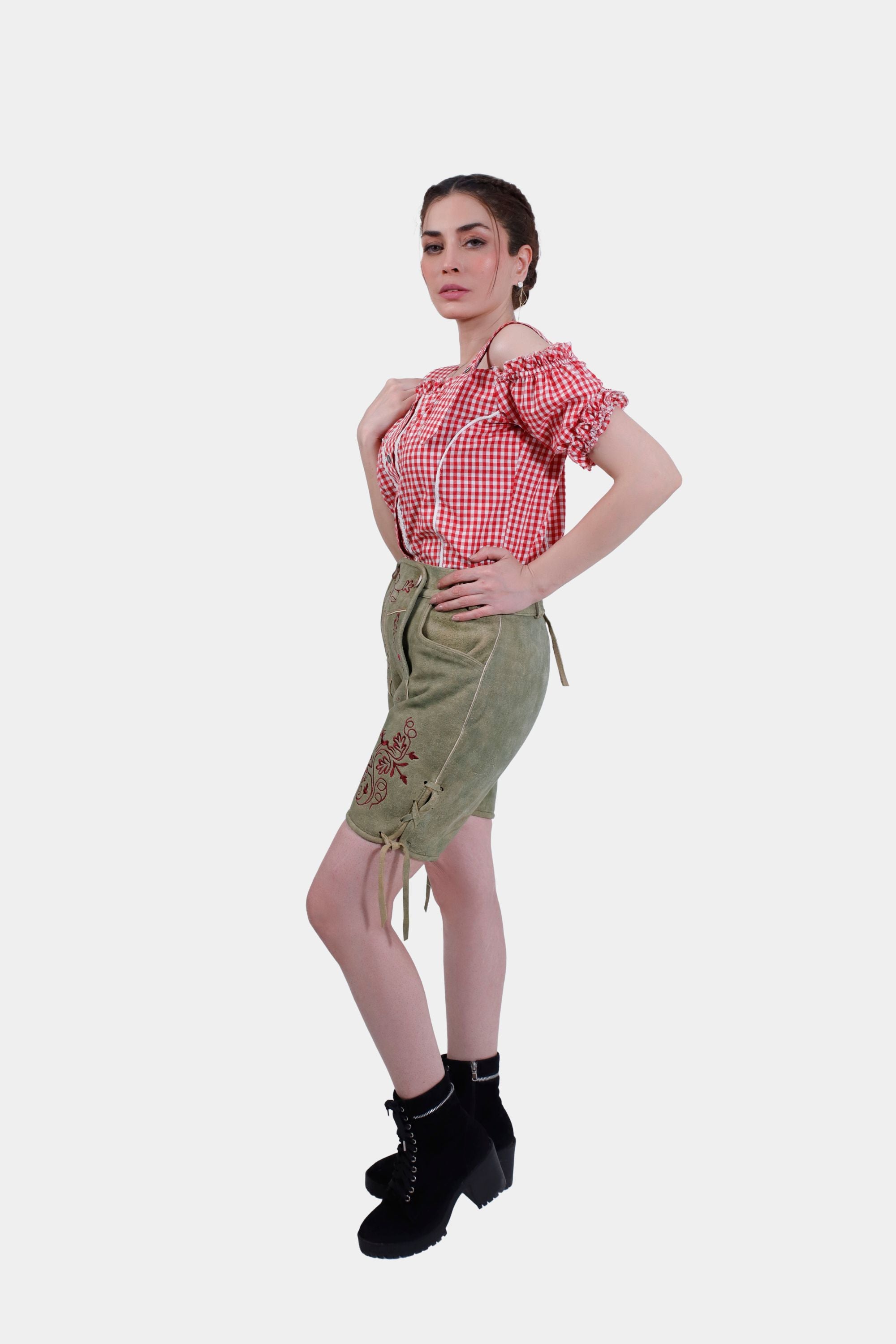 Full side view of a woman wearing Halle Berry Lederhosen in Olivewood Leaf, showcasing the adjustable waistband with laces on the cuffs.