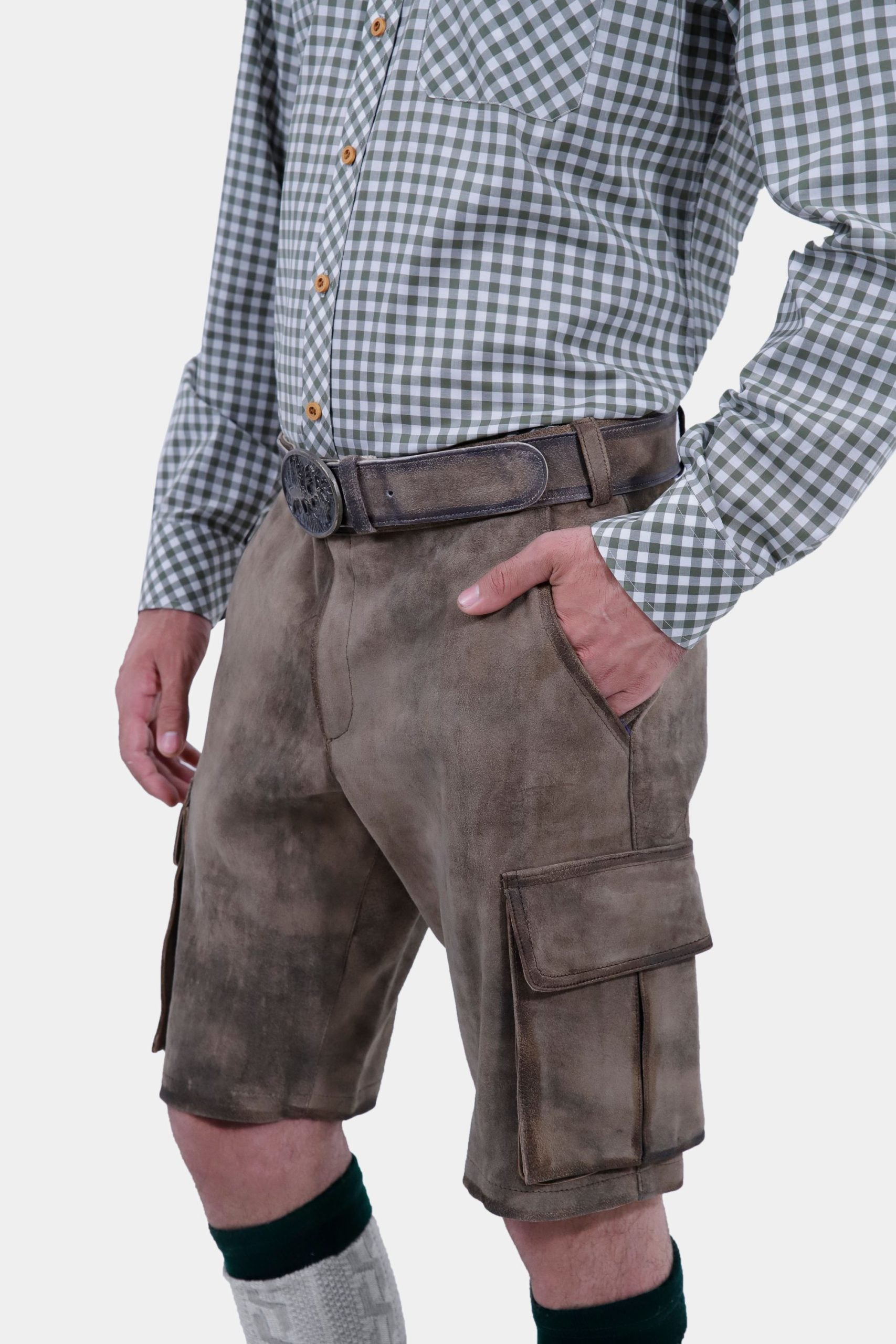 Close-up view focusing on the waist and pocket area of a man wearing grey leather lederhosen and a grey and white checkered shirt. The man has his right hand in the pocket, highlighting the belt and detailed stitching on the lederhosen.