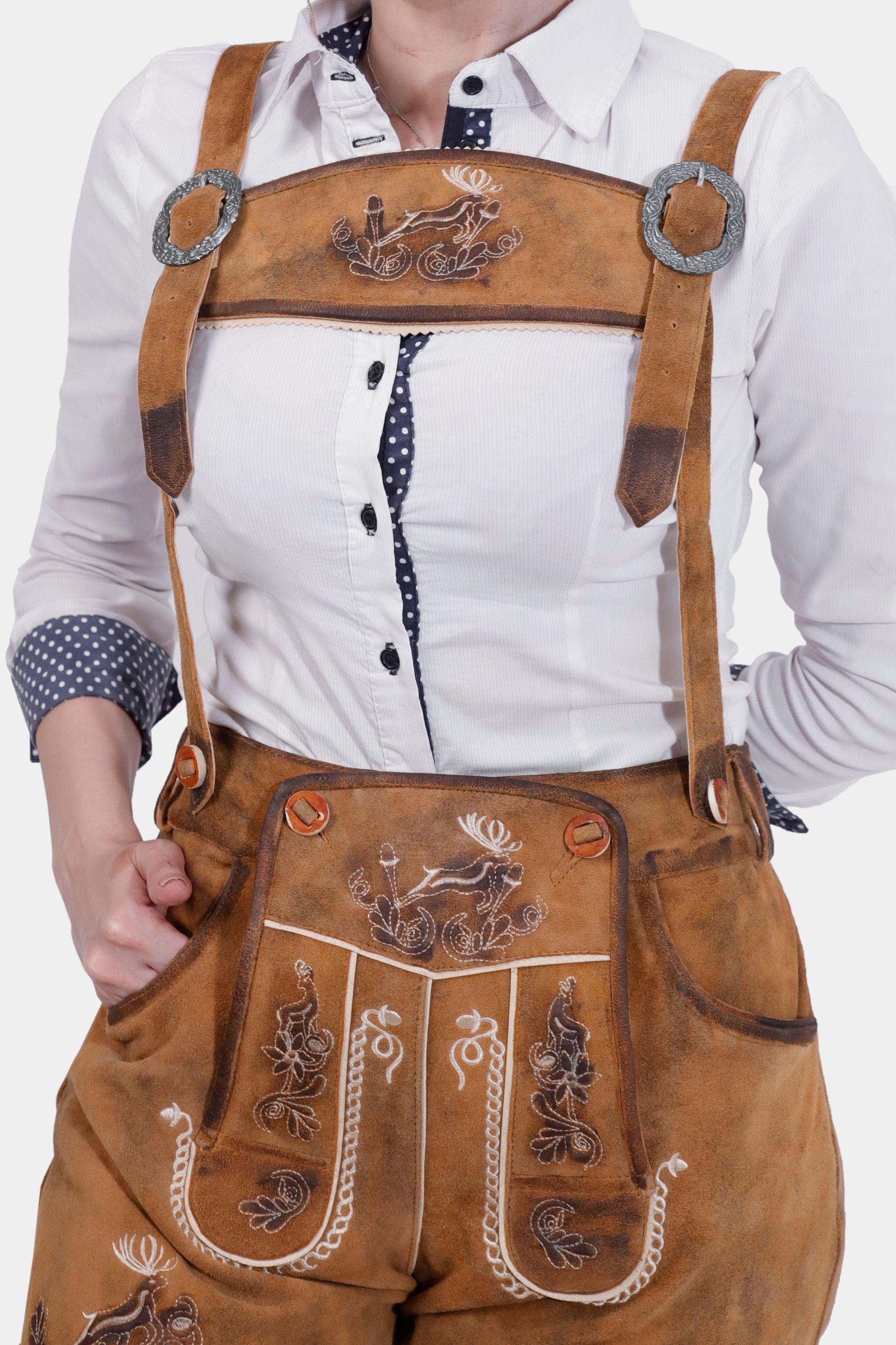 Close-up of the Hedy Lamarr Lederhosen showing the detailed white embroidery on the bib, paired with a white blouse with polka dot accents. The image highlights the quality and design of the Lederhosen.