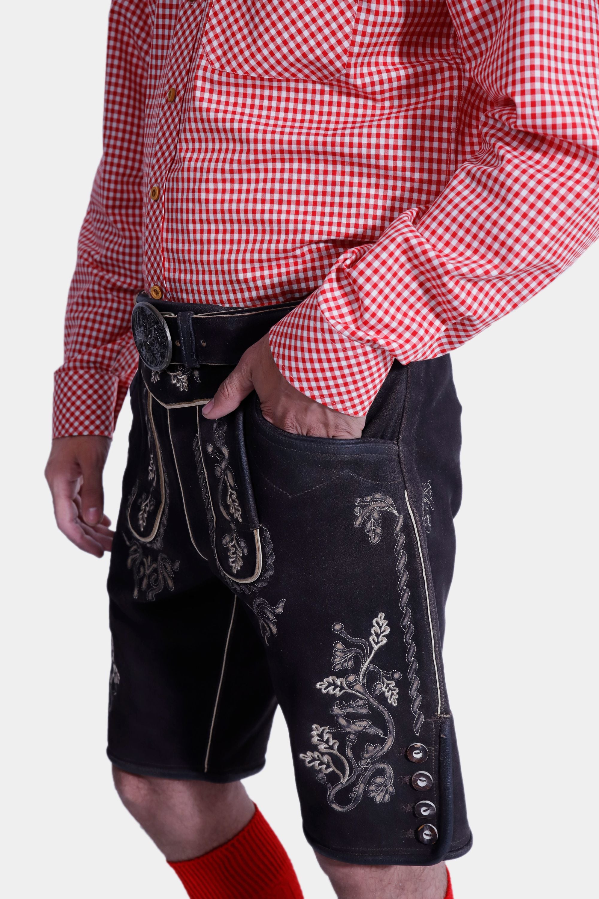 Close-up view of the Hoffman Lederhosen Outfit showing the detailed embroidery on the black Lederhosen, paired with a red and white checkered shirt.