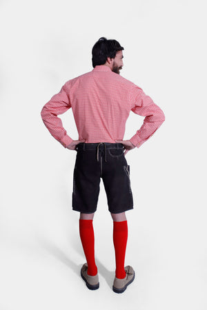 Back view of the Hoffman Lederhosen Outfit showing the black Lederhosen and red knee-length socks, with hands on hips.