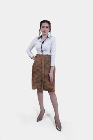 Full body Women wearing a traditional brown leather Karoline Lederhosen Skirt with subtle embroidery, paired with a white blouse featuring a polka-dotted inner collar