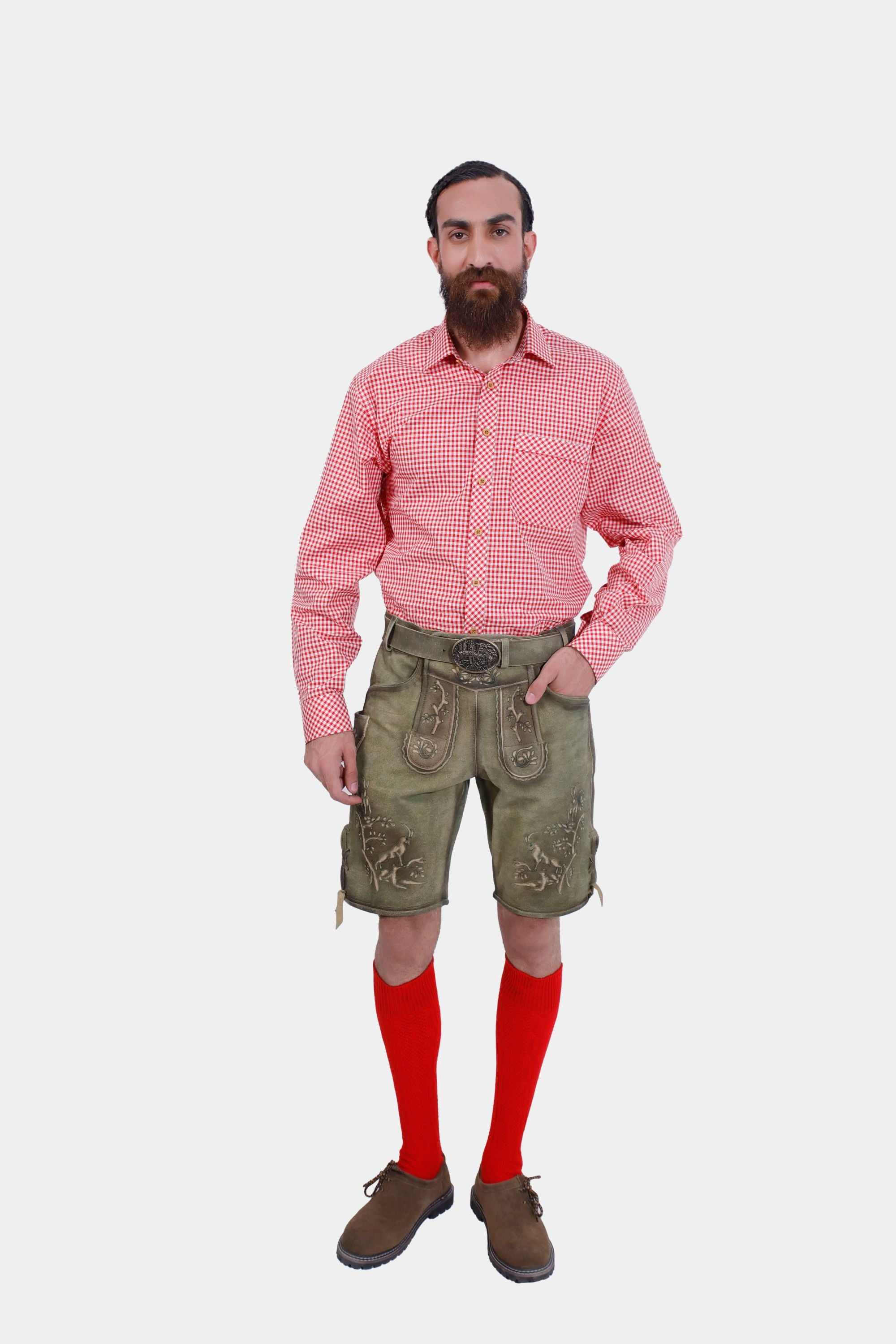 A man with a beard wearing a red checkered shirt, green embroidered Lederhosen, and red knee-high socks, standing against a white background.